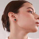 Close up of Emira Verde 18k gold-plated studs with green stone and sparkling accents, perfect for everyday elegance